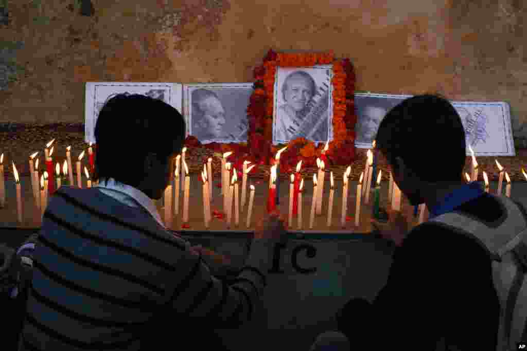 Indian students light candles to pay tribute to Ravi Shankar in Varanasi, where he was born in India, December 12, 2012.