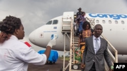 Una funcionaria de salud usa un termómetro para evaluar a los pasajeros que llegan al aeropuerto de Mbandaka, en la República Democrática de Congo. Mayo 19, 2018.