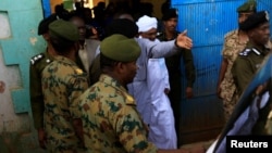 Sudan's former President Omar al-Bashir is escorted as he walks out from the National Prison in Khartoum, June 16, 2019.