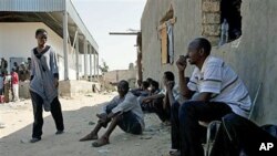 Des immigrants africains se mettent à l'abri des forces du CNT à Tripoli, le 28 août 2011