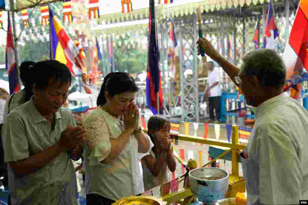 ពុទ្ធបរិស័ទកំពុងឈរទទួលពរនៅក្នុងវត្តមួយកណ្តាលរាជធានីភ្នំពេញកាលពីព្រឹកថ្ងៃសៅរ៍ ទី១៦ ខែ កញ្ញា ឆ្នាំ២០១៧។(ទុំ ម្លិះ/VOA)