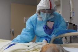 Angelica Mendez says goodbye to her mother, Catalina Salazar, 86, who was struggling to fight the coronavirus disease (COVID-19) at United Memorial Medical Center in Houston, Texas, Sept. 8, 2020.