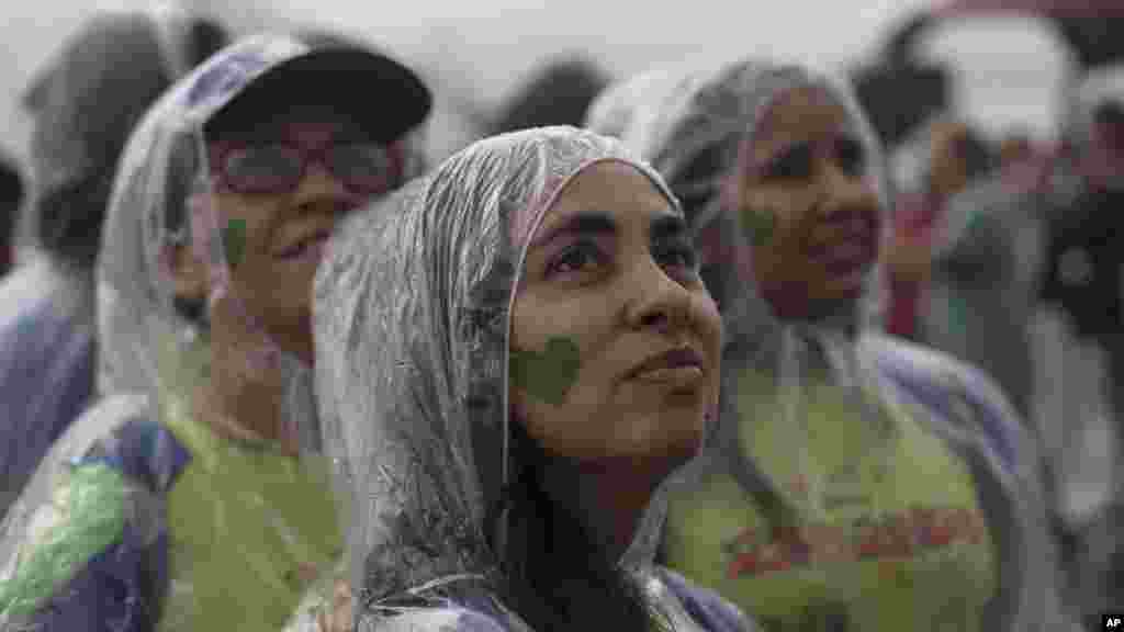 Para demonstran Pawai Iklim Rakyat di bawah hujan di pantai Ipanema, Rio de Janeiro, Brazil (21/9). (AP/Silvia Izquierdo)