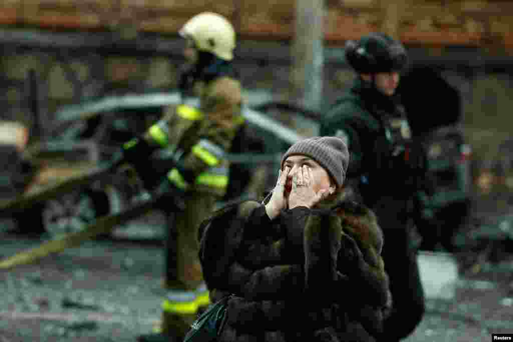 A woman reacts at the site of a Russian missile strike, amid Russia's attack on Ukraine, in central Kyiv, Ukraine.