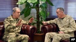 The U.S. chairman of the Joint Chiefs of Staff, Gen. Joseph Dunford, right, and Turkey's Chief of Staff Gen. Hulusi Akar talk during a meeting in Incirlik Airbase in Adana, Turkey, Feb. 17, 2017.