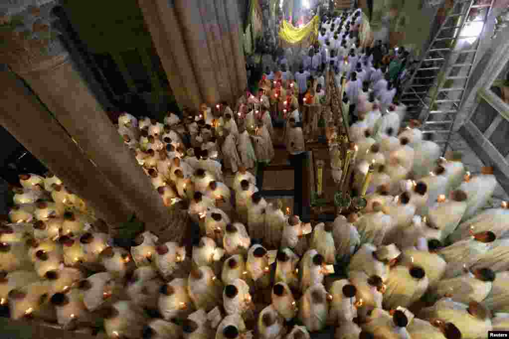 Members of the Catholic clergy hold candles as they take part in a procession at the Washing of the Feet ceremony during Holy Week in the Church of the Holy Sepulchre in Jerusalem's Old City, March 28, 2013.