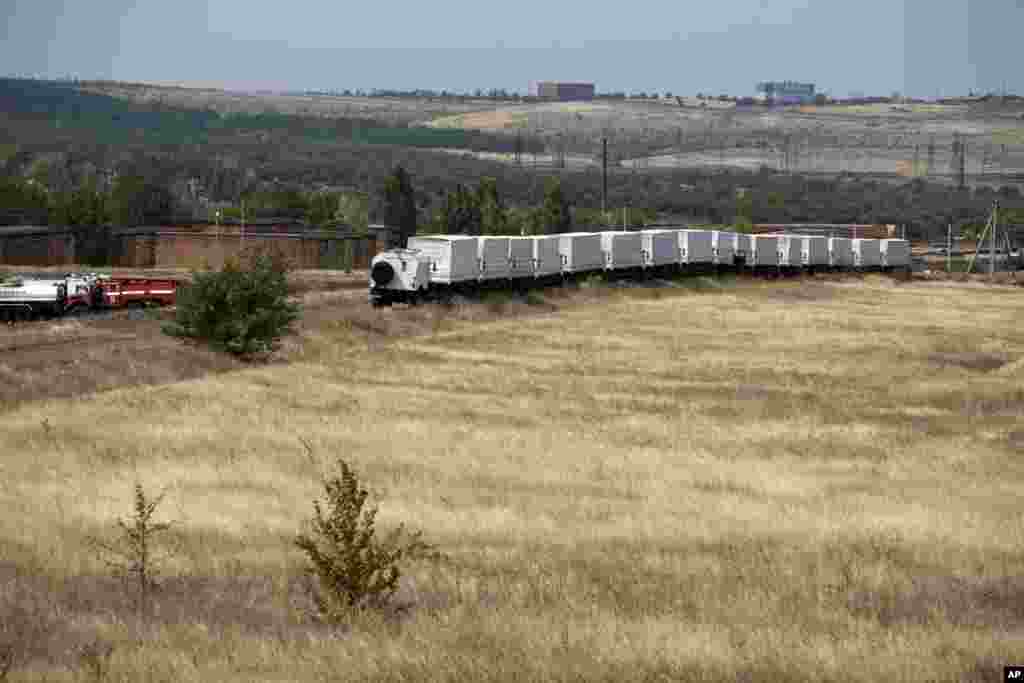 Sixteen trucks forming part of an aid convoy, wait in a field about 28 kilometers from a Russia-Ukraine border control point, Aug. 18, 2014. 
