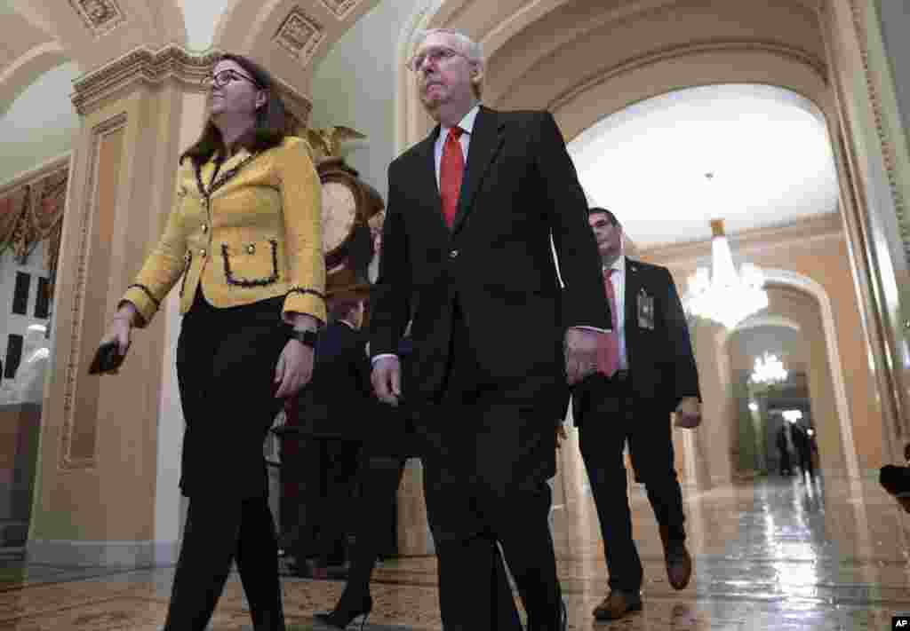  Kiongozi wa waliowengi katika Baraza la Seneti Mitch Mc Connell, kulia, akiwa na Katibu wa waliowengi Laura Dove, kushoto, akirejea katika ukumbi wa Bunge mjini Washington, Jumanne usiku, Januari 21, 2020.(AP Photo/J. Scott Applewhite)