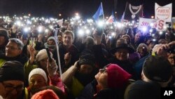 FILE - People take part in a street protest to show solidarity with judges facing increased political pressure from the country's right-wing government, in Warsaw, Poland, Dec. 1, 2019.