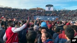 FILE - Student demonstrators stage a protest, in part against the continued use of fossile fuels, at a football game between Harvard and Yale in New Haven, Connecticut, Nov. 23, 2019.