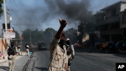 Police clear burning tire road blocks set by protesters upset with growing violence in the Lalue neighborhood of Port-au-Prince, Haiti, Wednesday, July 14, 2021. Haitian President Jovenel Moise was assassinated on July 7. (AP Photo/Fernando Llano)