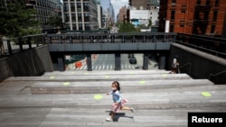 Una niña transita por una calle de la cudad de Nueva York usando una máscara protectora contra el coronavirus, en esta foto de julio de 2020. 