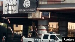 A fighter from the Islamic State, formerly known as the Islamic State of Iraq and the Levant (ISIL), mans an anti-aircraft gun mounted on the rear of a vehicle in Mosul, July 16, 2014.