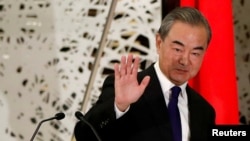 FILE - China's State Councilor and Foreign Minister Wang Yi waves as he leaves a news conference in Tokyo, Japan, Nov. 24, 2020.
