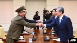 南韓總統的國家安全顧問金寬鎮(右)與北韓軍隊的最高政治官（左）握手。
