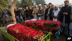 Siraj-ul-Haq (empty dari kanan), pimpinan partai Jammat-e-Islami, memimpin doa untuk jenazah korban pembantaian di sekolah Peshawar, Pakistan (17/12).