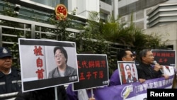 資料照：香港抗議者在北京駐香港機構中聯辦前手舉銅鑼灣書店失踪老闆桂民海的照片。 （2016年1月19日）