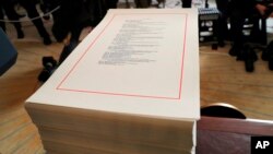FILE - A copy of the $1.3 trillion spending bill is stacked on a table in the Diplomatic Room of the White House in Washington, March 23, 2018.