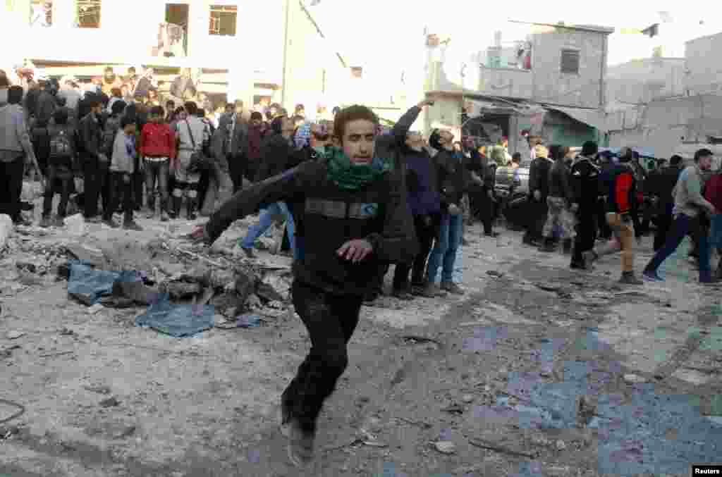 People run after what activists said was the return of government jet planes in the al-Marja district of Aleppo, Dec. 23, 2013. 