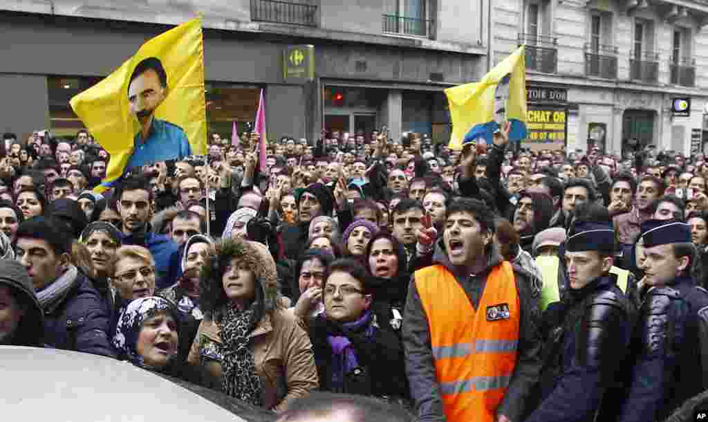 Kurdish people react as three bodies of the killed Kurdish women are taken out of a building in Paris, France, January 10, 2013.