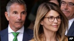 Actress Lori Loughlin, front, and husband, clothing designer Mossimo Giannulli, left, depart federal court in Boston after facing charges in a nationwide college admissions bribery scandal, Apr. 3, 2019.