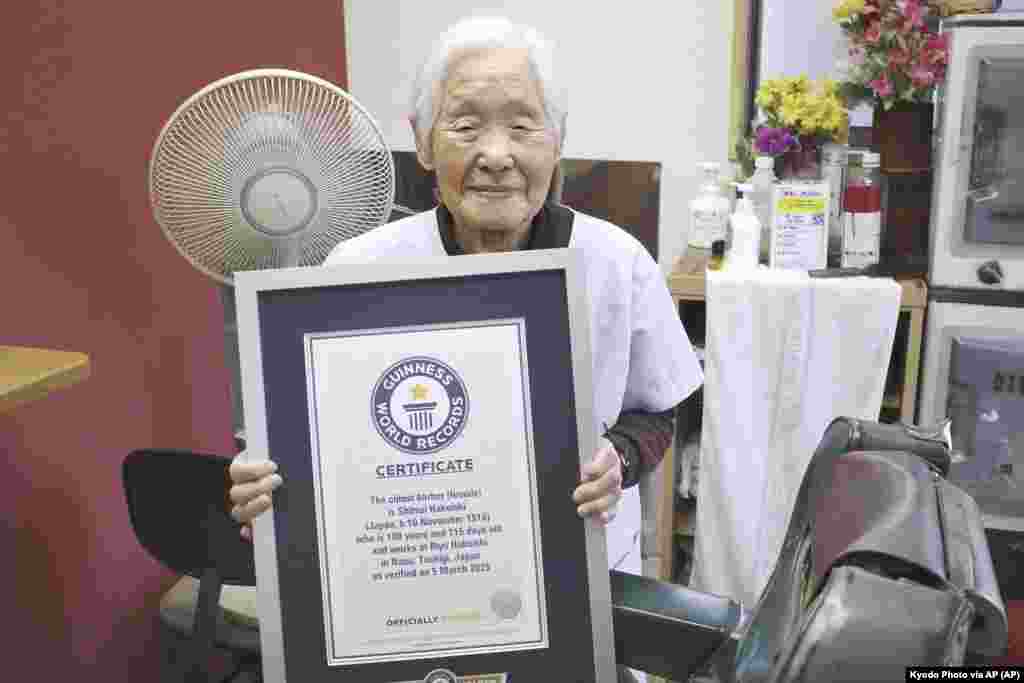 Shitsui Hakoishi, 108, poses for a photo with a Guinness World Records certificate recognizing her as the world's oldest female barber, at her shop in Nakagawa in Tochigi Prefecture, eastern Japan, on Wednesday March 5, 2025.