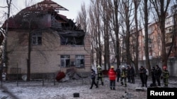 Tim SAR dan polisi memeriksa lokasi bangunan yang hancur akibat serangan pesawat tak berawak Rusia di Kyiv, Ukraina, 14 Desember 2022. (REUTERS/Gleb Garanich)