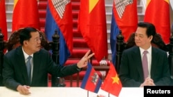 Cambodia's Prime Minister Hun Sen (L) chats with his Vietnamese counterpart Nguyen Tan Dung before a signing ceremony at the Government Office in Hanoi December 26, 2013. 