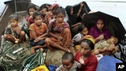 Rohingya Muslims who fled Burma to Bangladesh sit in a boat after being intercepted by Bangladeshi border authorities in Taknaf, Bangladesh, June 13, 2012.