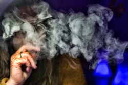 FILE - A woman takes a puff from a cannabis vape pen in Los Angeles, Dec. 22, 2018.