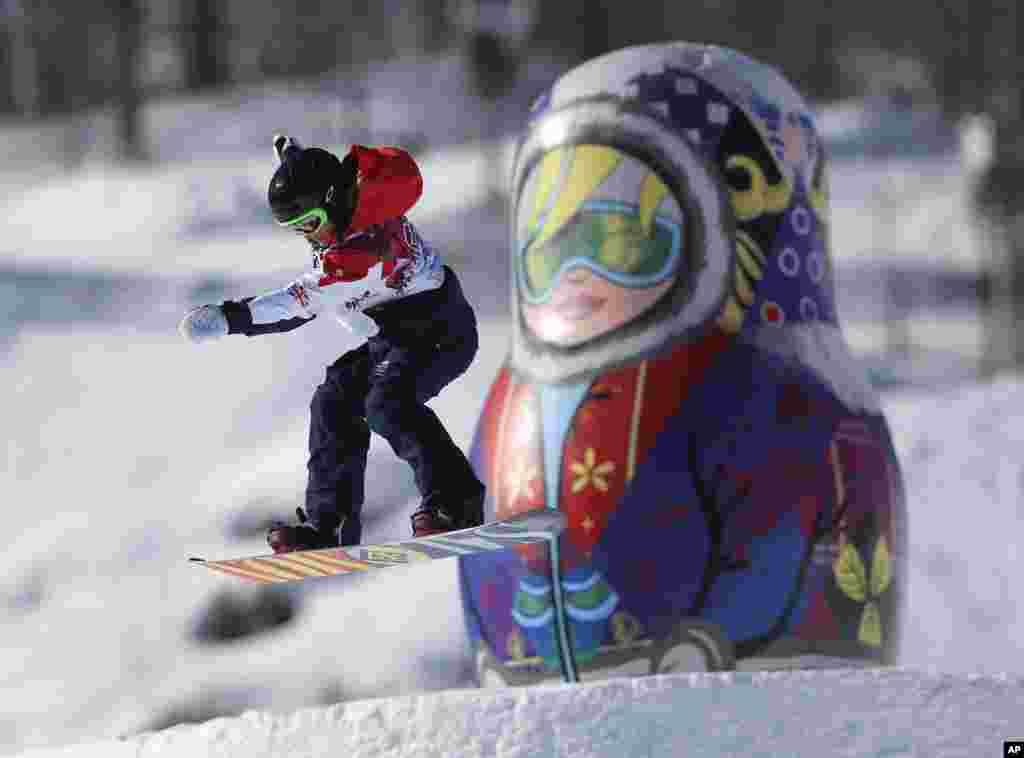A competitor takes a jump past a giant matryoshka doll during a Snowboard Slopestyle training session at the Rosa Khutor Extreme Park, prior to the 2014 Winter Olympics, Feb. 4, 2014.