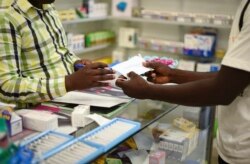 In this Feb. 6, 2020, photo, a man buys a face mask at a pharmacy in Kitwe, Zambia. The coronavirus that has spread through much of China has yet to be diagnosed in Africa, but global health authorities are increasingly worried about the threat.