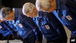 FILE - Tokyo Electric Power Co., (TEPCO) Chairman Tsunehisa Katsumata, center, and others bow before a news conference at the company's head office in Tokyo, March 30, 2011. 