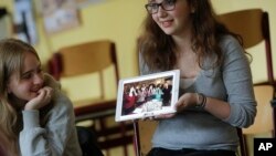Jewish teenager Sophie Steiert, right, shows a picture of Jewish daily life on a tablet computer as Laura Schulmann looks on during a lesson as part of a project of religions at the Bohnstedt Gymnasium high school in Luckau, Germany, June 25, 2018.