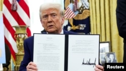 도널드 트럼프 미국 대통령이 2025년 2월 13일 워싱턴D.C 백악관 오벌오피스에서 각국에 ‘상호주의적 관세’를 부과하는 메모에 서명한 후 들어보이고 있다.