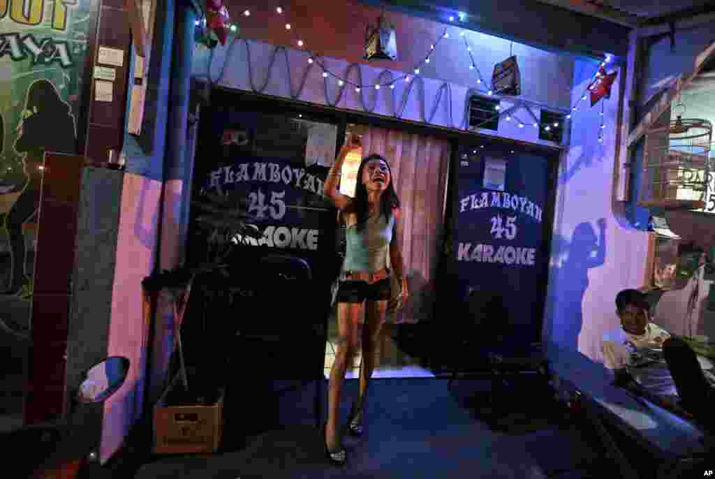 Seorang 'gadis karaoke' meneriakkan protes melawan langkah pemerintah kota Surabaya menutup kompleks lokalisasi Dolly (19/6). (AP/Dita Alangkara)