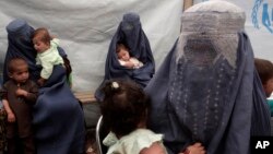 Returning Afghan refugees, who have recently arrived from Pakistan, wait during the registration process at a United Nations High Commissioner for Refugees center on the outskirts of Kabul, Afghanistan, June 20, 2013.