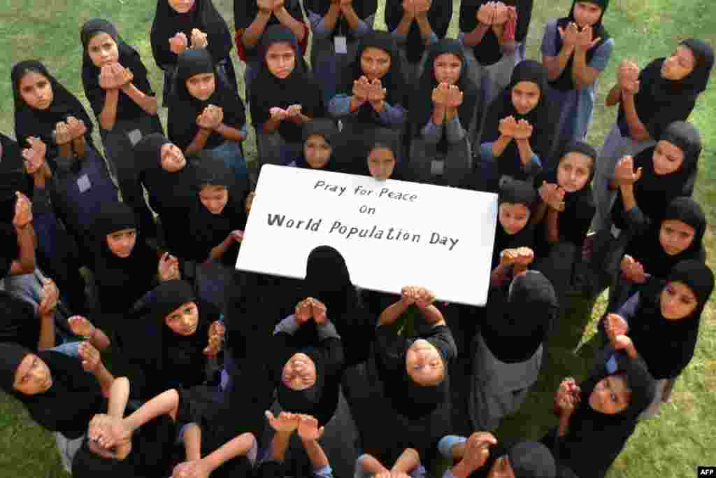 Muslim schoolgirls pose as they pray for 'World Peace' on 'World Population Day' in Jodhpur, India. World Population Day, which was established by the U.N. Development Program in 1989, is observed annually to raise awareness of global population issues.