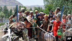 Ethnic Uzbek refugees cross the Kyrgyz-Uzbek border on their way back to Kyrgyzstan, 18 June 2010