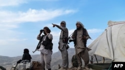 FILE - Afghan militia fighters keep watch at an outpost against Taliban insurgents at Charkint district, Balkh province, Afghanistan, July 15, 2021. 