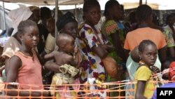 FILE - Internally-displaced people wait in line for medical attention at the 'Medecins sans Frontieres' (MSF) hospital based in the IDP camp near the international airport in Bangui, Dec. 23, 2013. 