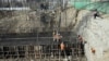 FILE - In this Feb. 10, 2020 photo, Afghan laborers work on a bridge project funded by the government, in Kabul, Afghanistan. 