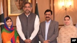In this photo released by the Press Information Department, Pakistani Nobel Peace Prize winner Malala Yousafzai, left, and her parents stand for a photograph with Shahid Khaqan Abbasi, second from left, Prime Minister of Pakistan in Islamabad, Pakistan, Thursday, March 29, 2018. (Press Information Department via AP)