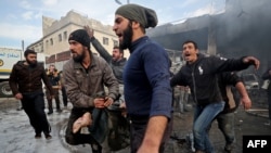 Syrians carry away the body of a man retrieved from the rubble of a building following a regime air strike on a vegetable market in Syria's last major opposition bastion of Idlib on January 15, 2020. - Regime air strikes on Syria's last major…