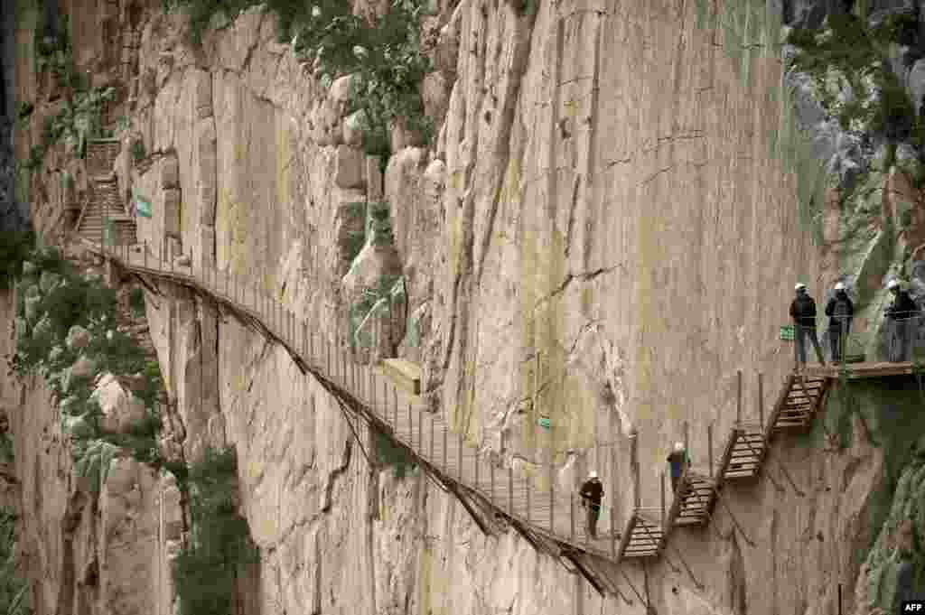 Para wartawan berjalan dalam kunjungan ke jalan setapak "El Caminito del Rey" (jejak kecil Raja) jalan setapak yang sempit dan menggantung di dinding ngarai yang curam di Ardales dekat Malaga, Spanyol, 15 Maret 2015. Jalan selebar satu meter dan sepanjang 7,7 km, bergantung di ngarai Ardales di ketinggian 100 meter, ditutup di pertengahan 90an setelah banyak pemanjat tebing yang meninggal.