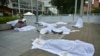 Activistas yacen cubiertos con sábanas que representan cadáveres afuera de la sede de la 49° Asamblea General de la OEA, para protestar contra el asesinato de líderes sociales y juveniles, en Medellín, Colombia, el 28 de junio de 2019. 
