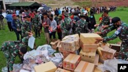 Soldados reparten suministros en el estadio de Mamuju, Sulawesi Occidental, a los afectados por un terremoto de magnitud 6,2 la semana pasada en Indonesia. 17 de enero de 2021. 