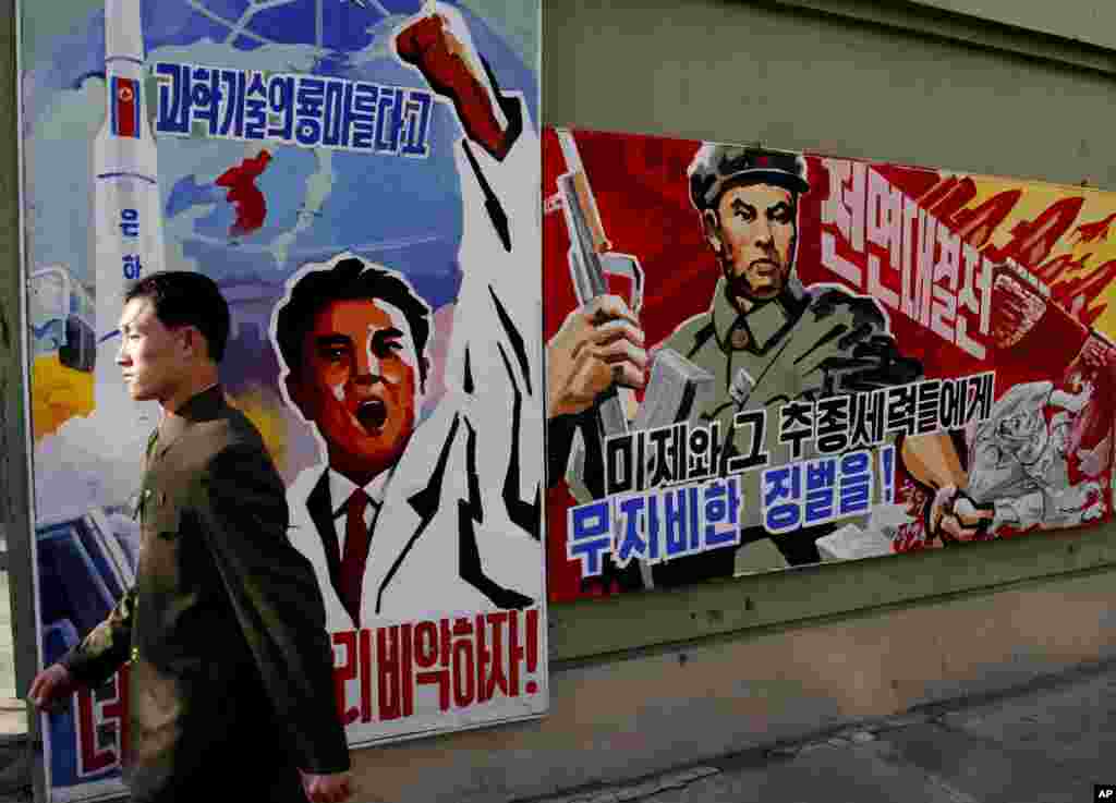 2013年3月26日，一位男士在平壤走过威胁要惩罚&ldquo;美帝国主义者及其同伙&rdquo;的宣传画。