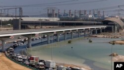 Vehículos circulan a través del agua estancada causada por fuertes lluvias en una rampa de acceso a la autopista Sheikh Zayed Road en Dubai, Emiratos Árabes Unidos, el jueves 18 de abril de 2024.