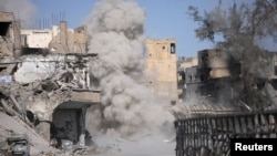 FILE - Smoke rises after a landmine exploded as fighters of Syrian Democratic Forces clear roads after pushing Islamic State militants out of Raqqa, Syria, Oct. 18, 2017. 